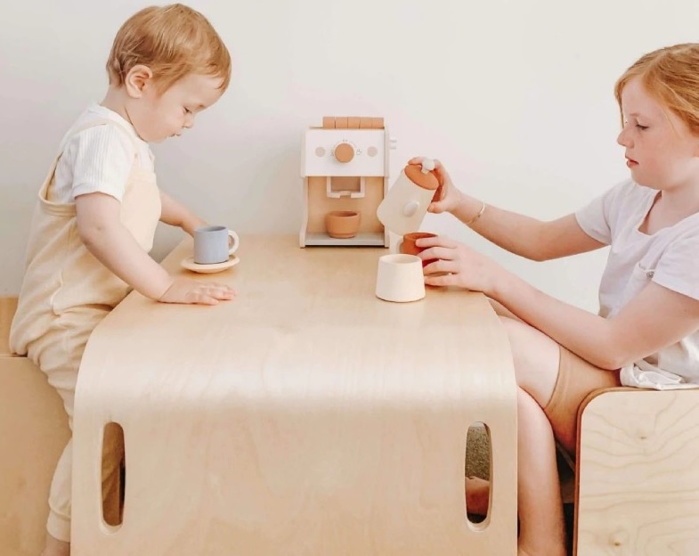 Two children playing at a solid-wood Cuddle Gently table